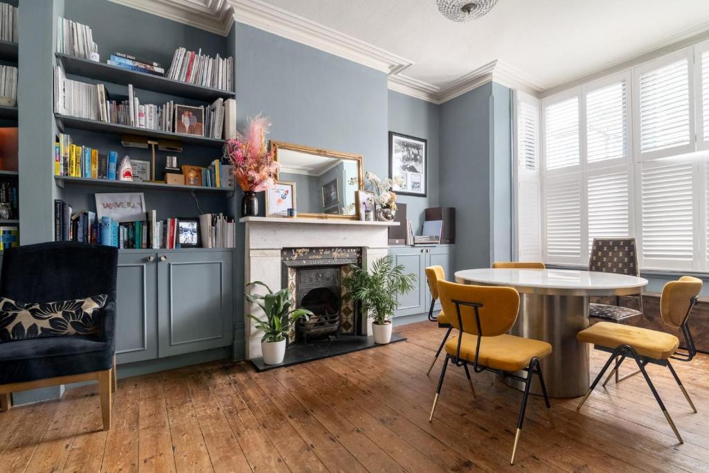 uma sala de estar com uma mesa e cadeiras e uma lareira em GuestReady - A charming stay in Highgate em Londres