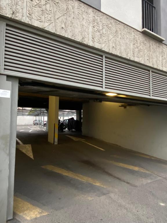 a parking lot with a car garage with a building at Le Mayda - Parking Privé Gratuit in Marseille