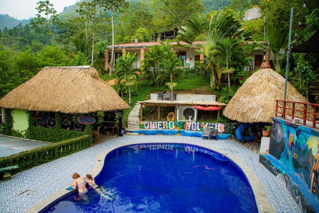 two people walking around a swimming pool at a resort at Viñas Hotel in Lanquín