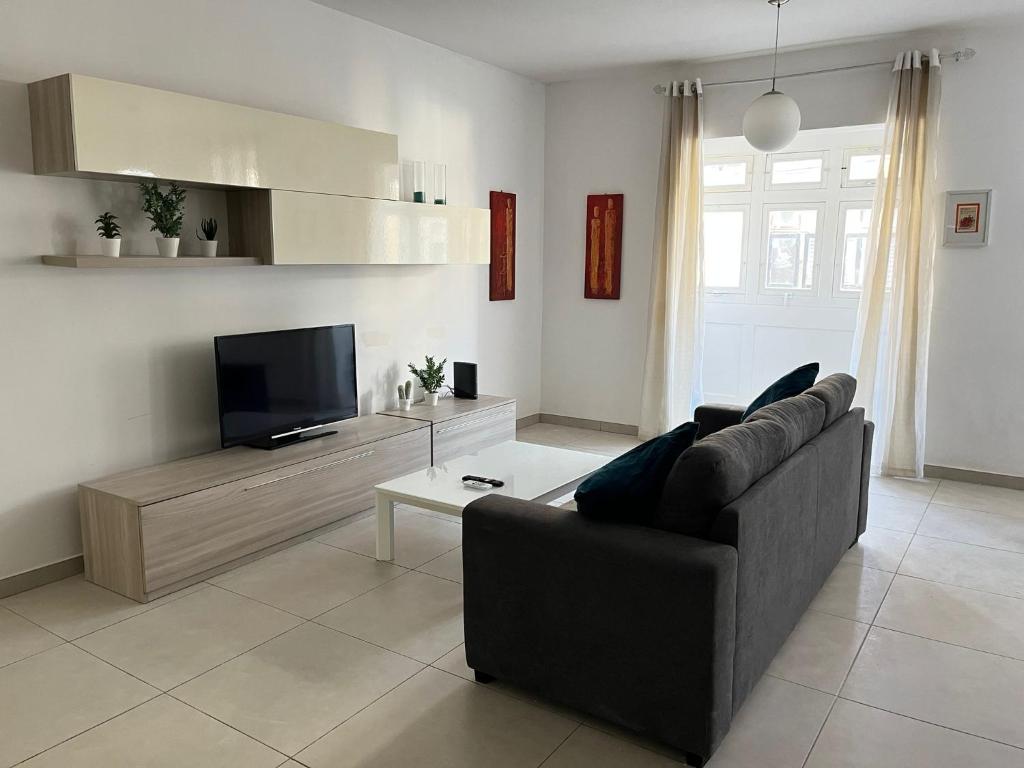 un soggiorno con divano e TV a schermo piatto di Superb 3BR apt close to seafront a Il-Gżira