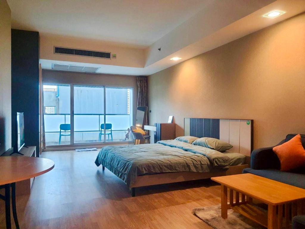 a bedroom with a bed and a living room at Baan Nonzee Condo in Bangkok