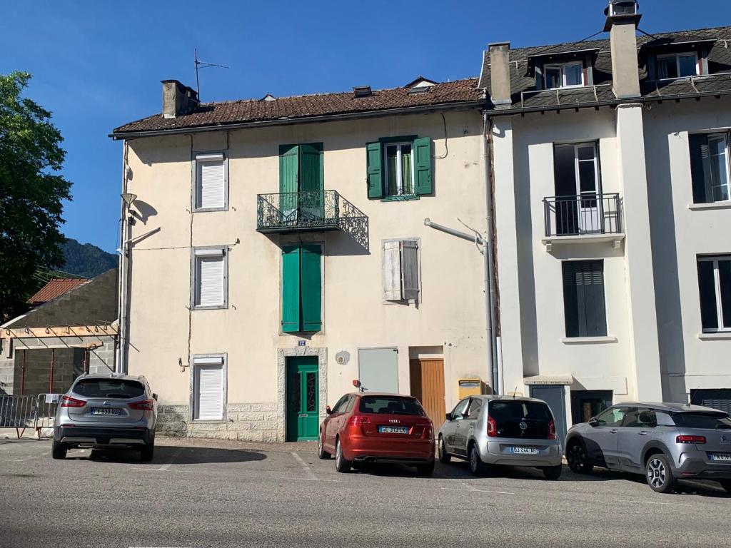 a group of cars parked in front of a building at Joli appartement dans une maison ancienne in Ax-les-Thermes