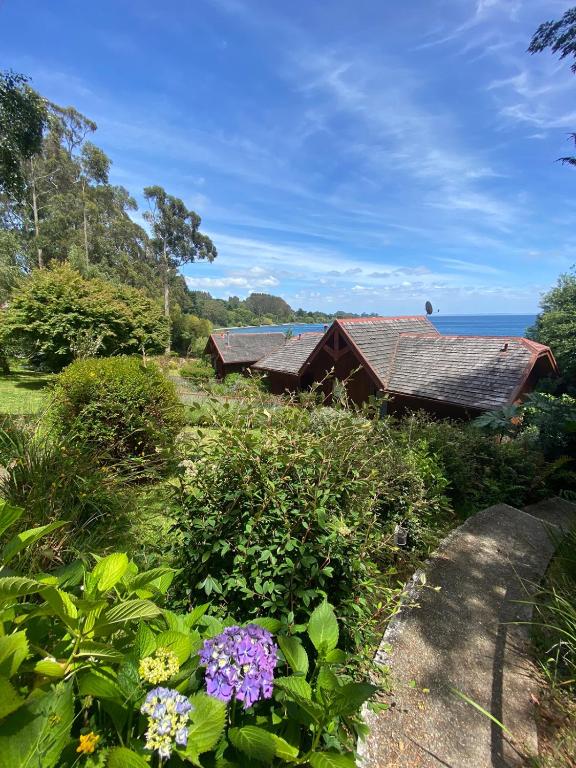 un jardín con flores frente a una casa en Cabañas Bahia Celeste, Puerto Varas en Puerto Varas