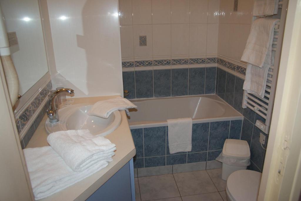 a bathroom with a tub and a sink and a toilet at La Vieille Auberge in Le Mont Saint Michel