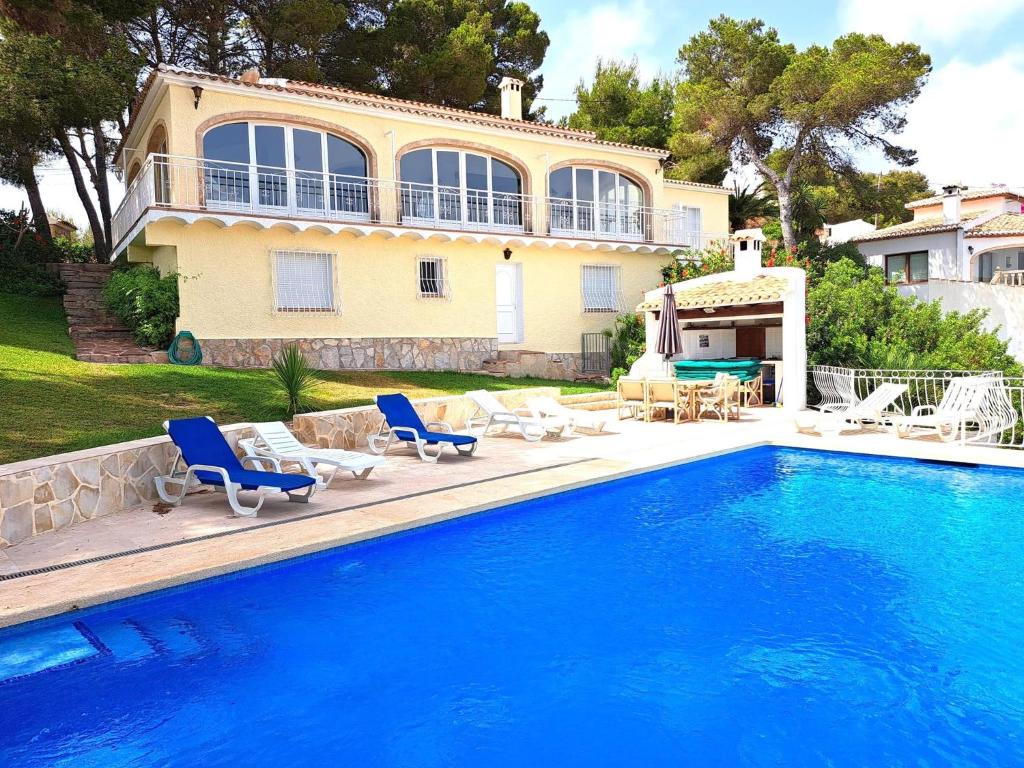 a house with a swimming pool in front of a house at Holiday Home Maria in Jávea