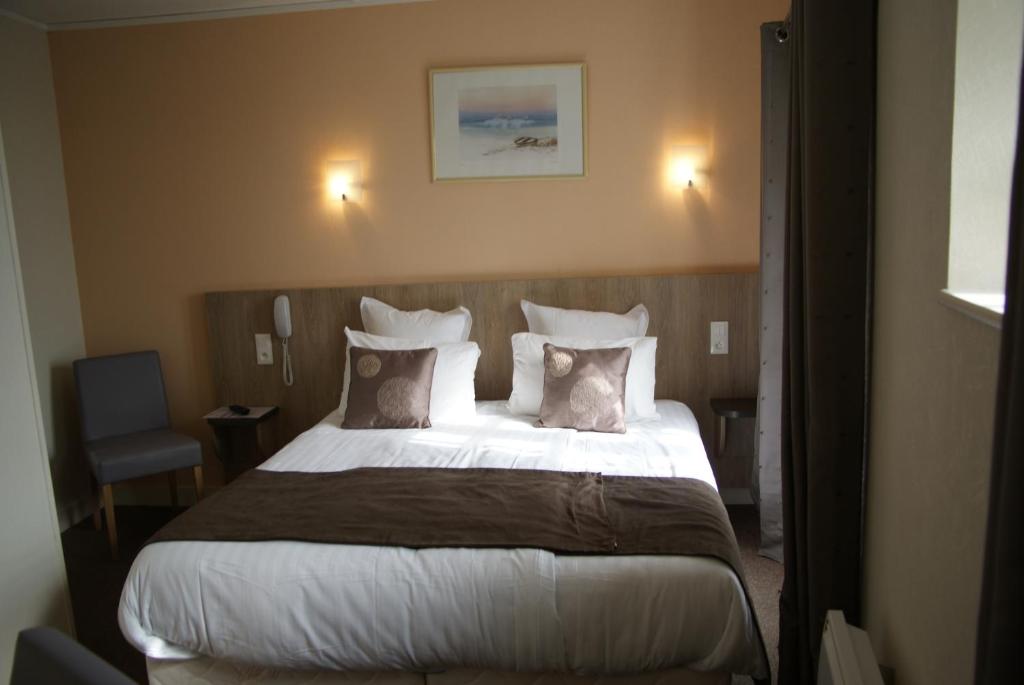 a hotel room with two beds and two lamps at La Vieille Auberge in Le Mont Saint Michel