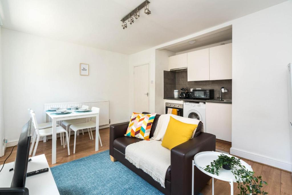 a living room with a couch and a table at Super 1BD Flat minutes from Kings Cross Station in London