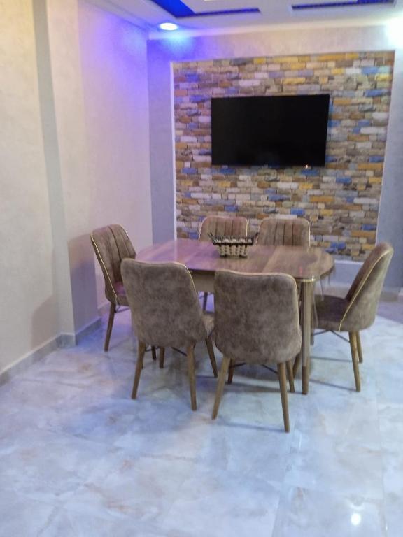 een eetkamer met een tafel en stoelen en een tv bij Appartement Saidia a 500 m de la plage in Saidia 