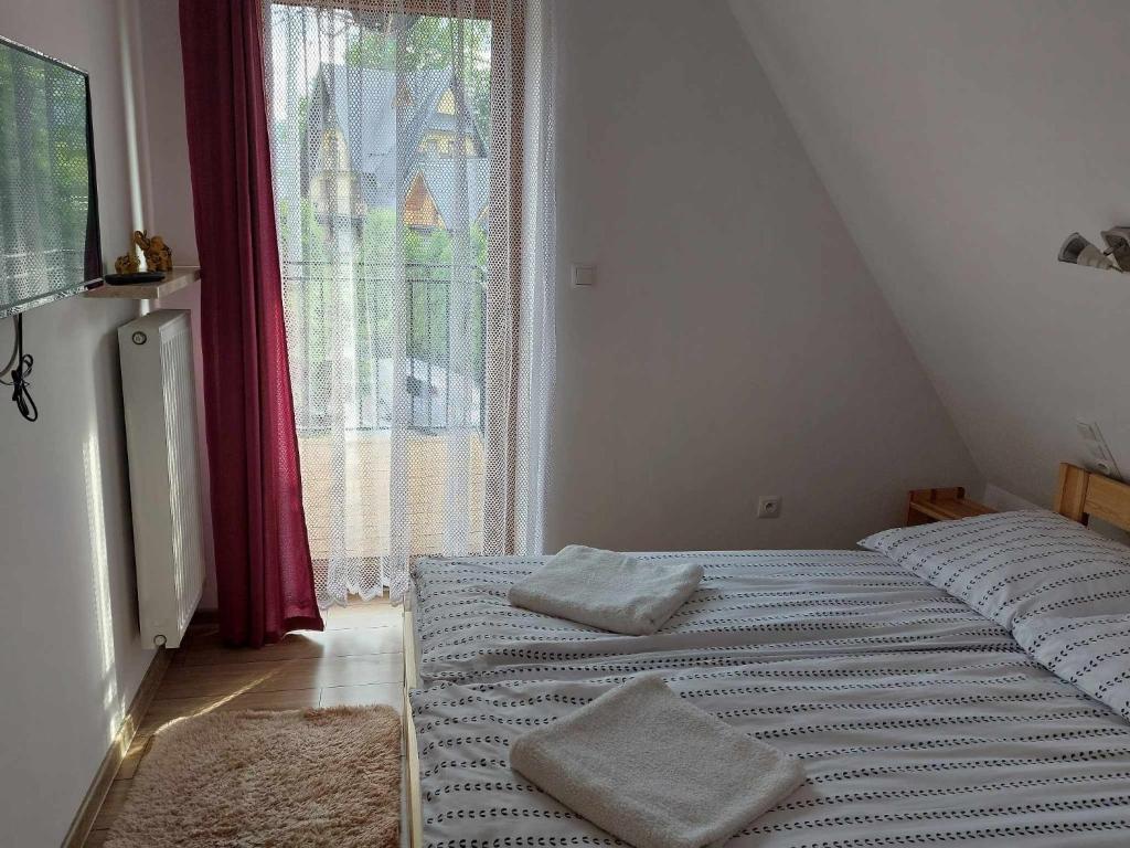 Posteľ alebo postele v izbe v ubytovaní Apartamenty CEDE Zakopane