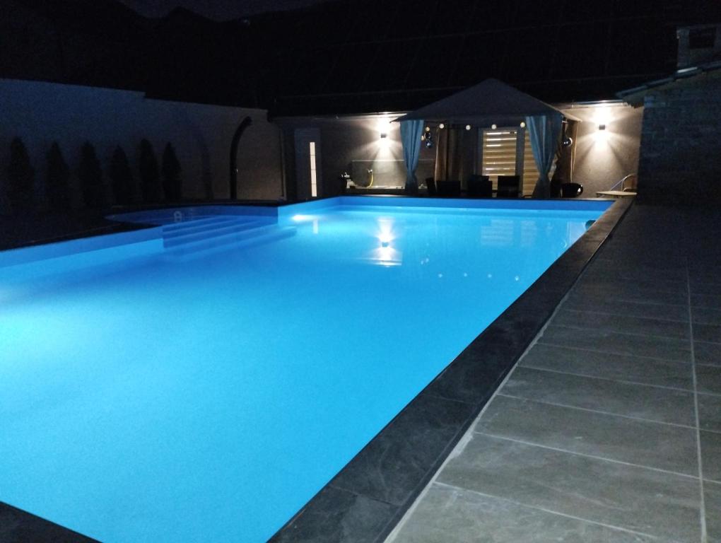 a large swimming pool at night with a gazebo at Villa Klaudija in Petrovaradin