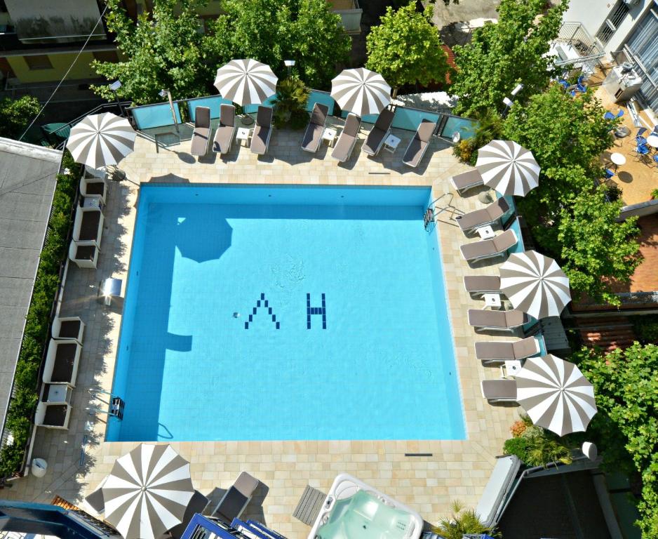an overhead view of a swimming pool with chairs and umbrellas at Hotel Verona in Cesenatico