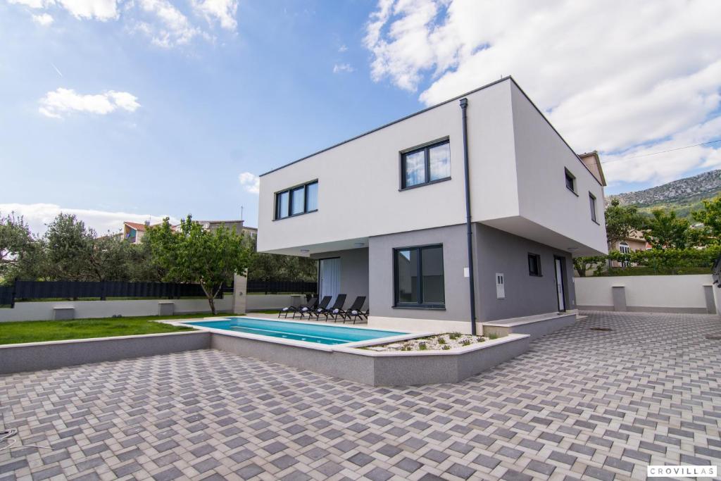 ein Haus mit einem Swimmingpool im Hinterhof in der Unterkunft Kastel One in Kaštela