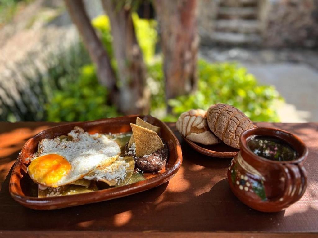 une table avec une assiette de nourriture et une tasse de sauce dans l'établissement Hospedaje Casa Teotleco, à Tepoztlán