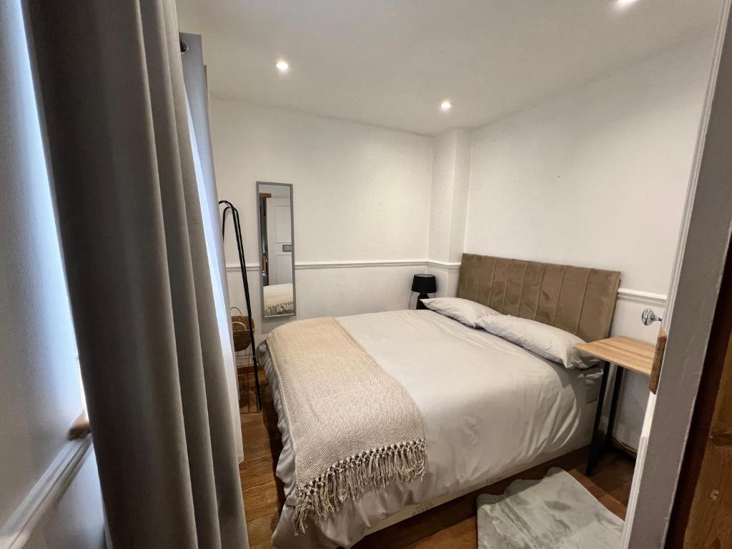 una piccola camera con letto e specchio di Cosy Single Room for ONE person a Bromley