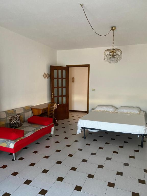 um quarto com uma cama, um sofá e um lustre em Casa vacanze Gilli em Cagliari