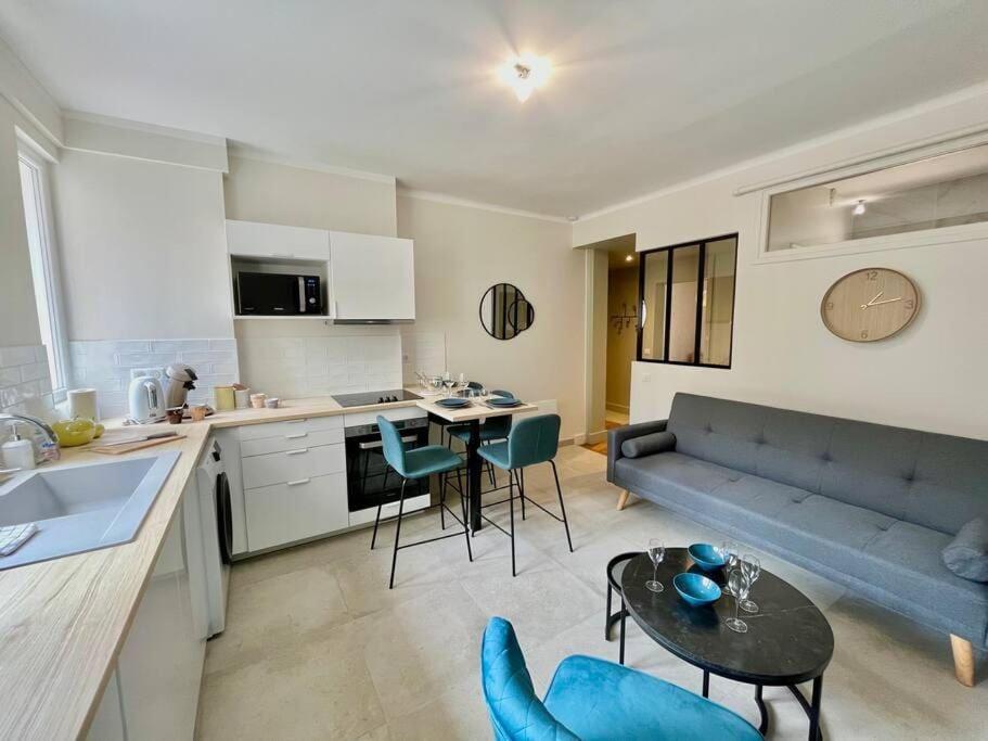 une cuisine et un salon avec un canapé et une table dans l'établissement HONEY - Reims Hypercentre, à Reims