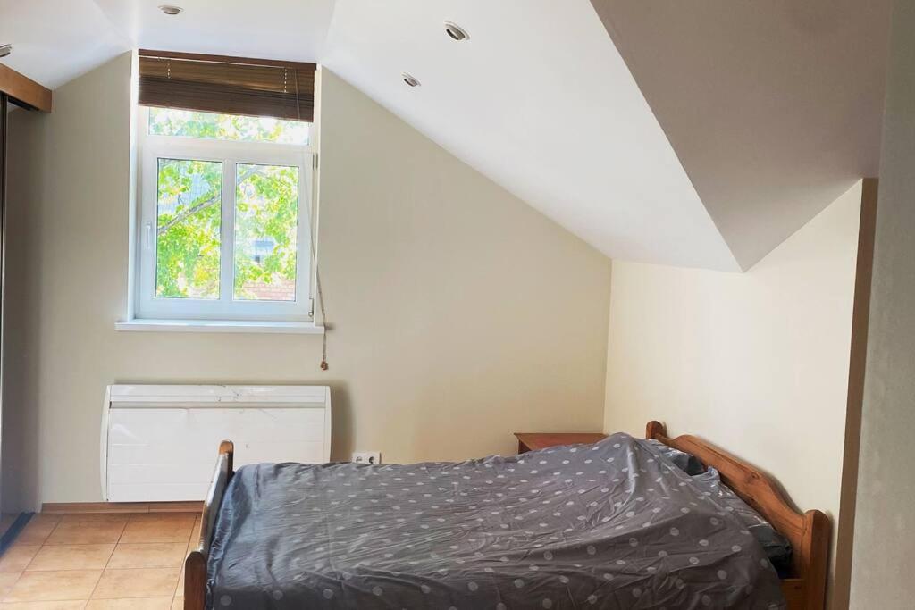 sypialnia z łóżkiem i oknem w obiekcie Homely 2 room apartment w mieście Lipawa