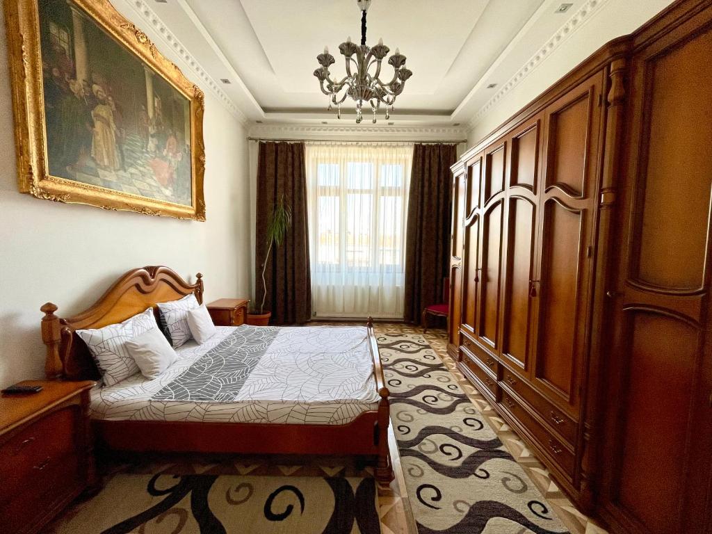 a bedroom with a bed and a chandelier at M & I Apartment 1 in Târgu-Mureş