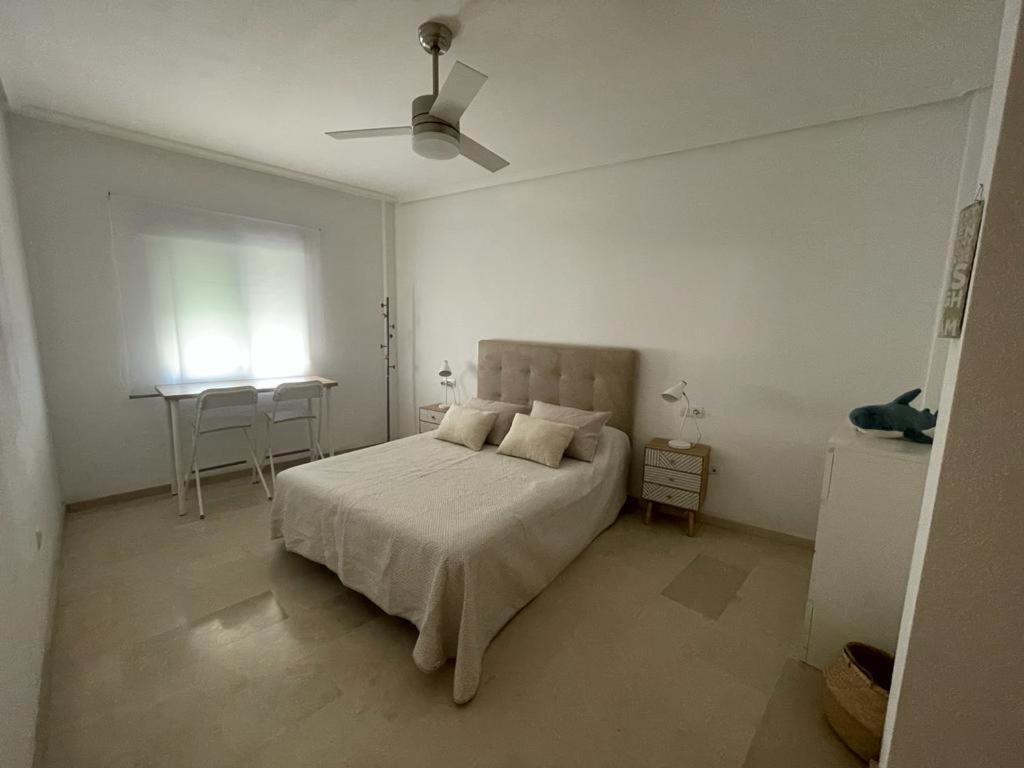um quarto branco com uma cama e uma ventoinha de tecto em Apartamento Vive Garrucha em Garrucha