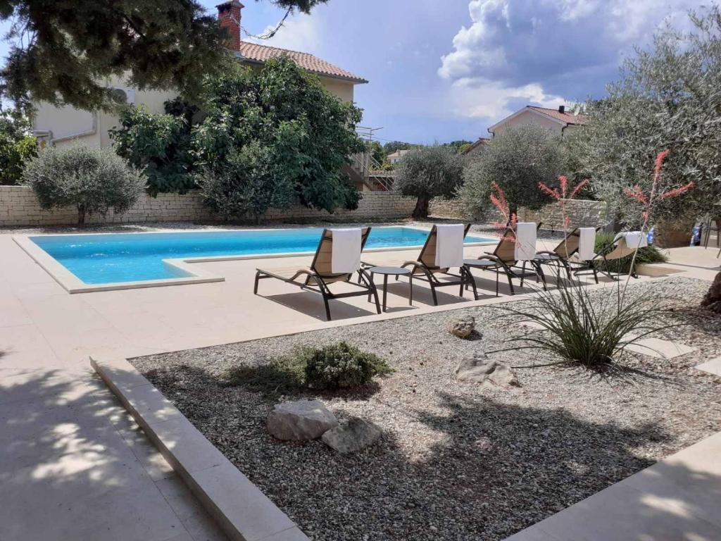 a group of chairs and a swimming pool at Caprice in Milohnići