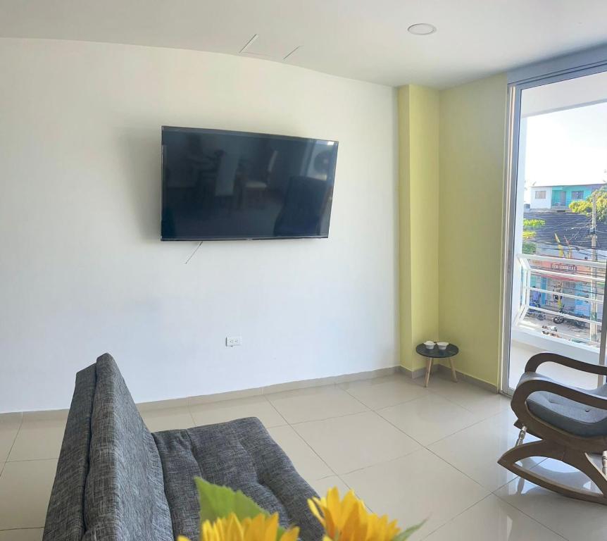 - un salon avec un canapé et une télévision murale dans l'établissement Apartamento 202, à Carthagène des Indes