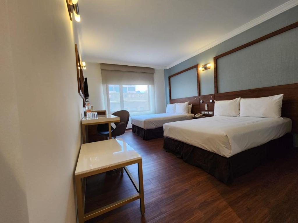Cette chambre comprend deux lits et un bureau. dans l'établissement Hotel Ritz Ciudad de México, à Mexico