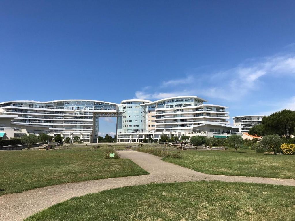 un grand bâtiment avec un chemin devant lui dans l'établissement GRAND STUDIO MER ET PORT DES MINIMES, à La Rochelle
