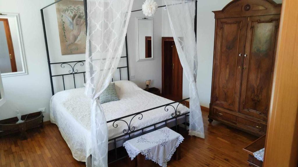 Traghetto vecchio house في كافالّينو تريبورتي: غرفة نوم بسرير مع مظلة