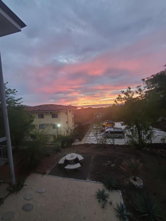 een uitzicht op de zonsondergang van een parkeerplaats met een bankje bij Villa Teresita - vista hermosa in Coco