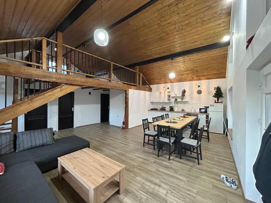 a living room with a staircase and a table and chairs at Cabana Tudor in Aiud