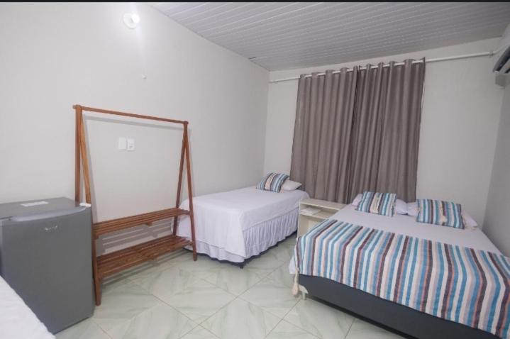 a hotel room with two beds and a mirror at Canoa Hospedagem in Barra Grande