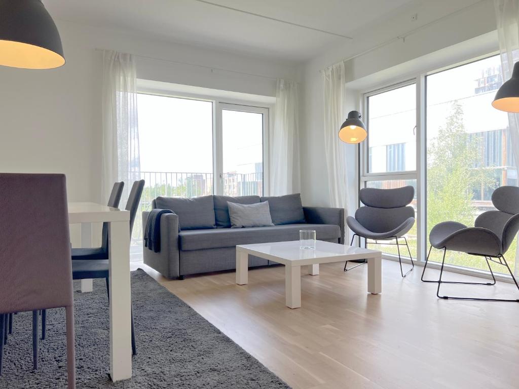 uma sala de estar com um sofá, uma mesa e cadeiras em Spacious 3 Bedroom Apartment With Balcony At Richard Mortensens Vej em Copenhaga