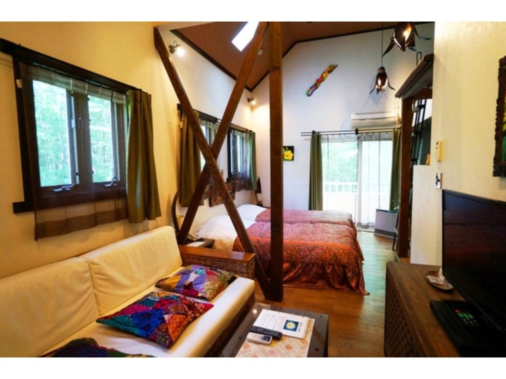 um quarto com uma cama, um sofá e uma mesa em Estivant Club - Vacation STAY 95711v em Tsumagoi