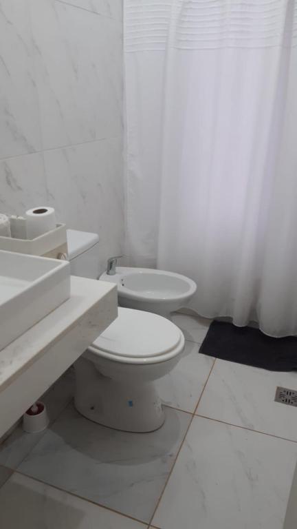 a white bathroom with a toilet and a sink at Depto Bonito in Posadas