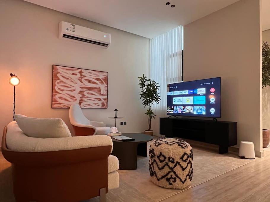 a living room with a couch and a flat screen tv at Luxury apartment with self check-in in Riyadh