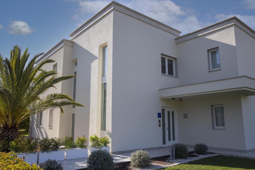 a white house with a palm tree in front of it at Celine in Savudrija