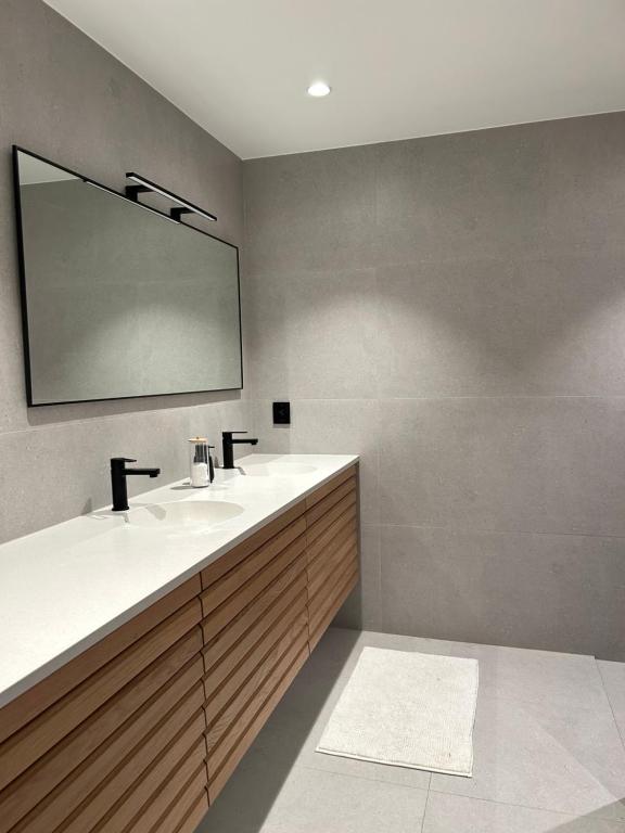 uma casa de banho com 2 lavatórios e um espelho em Single room em Trondheim