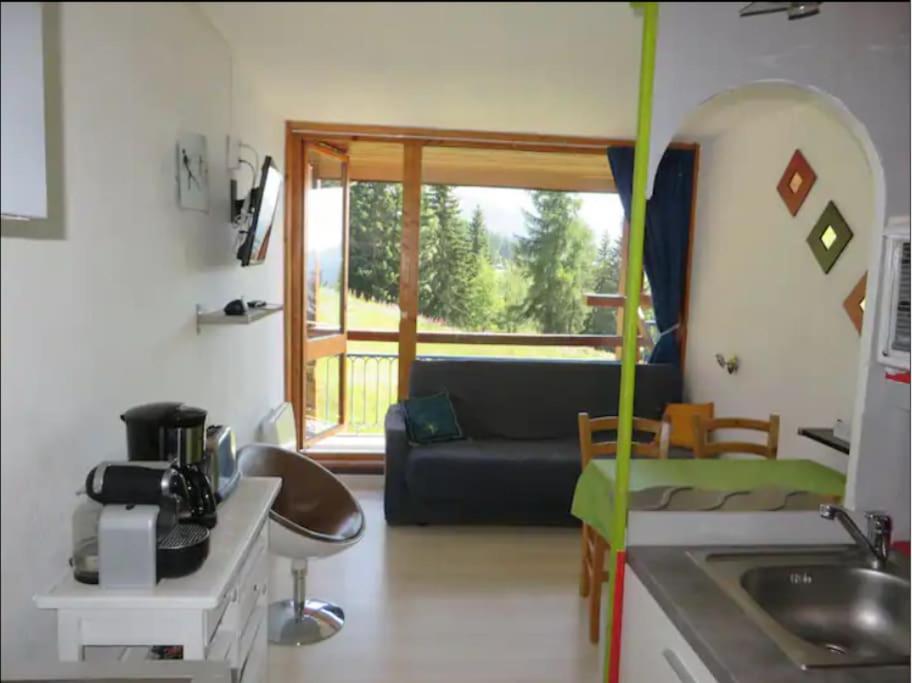 un salon avec un canapé et une cuisine dans l'établissement Arc 1800 - Studio 5p - Réservations du Samedi au Samedi uniquement, à Arc 1800