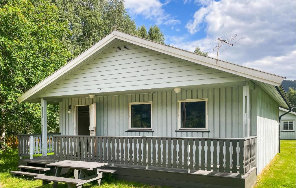 a green house with a picnic table in front of it at Amazing Home In Dovre With House A Panoramic View in Dovre