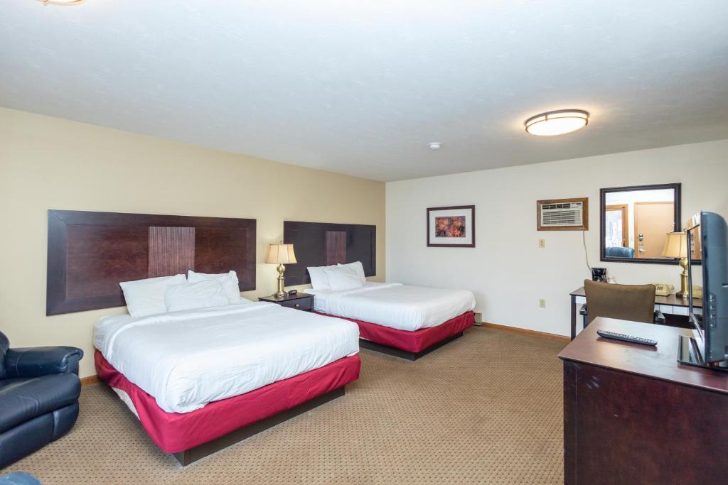 una camera d'albergo con due letti e una televisione di Brentwood Motor Inn a Marquette