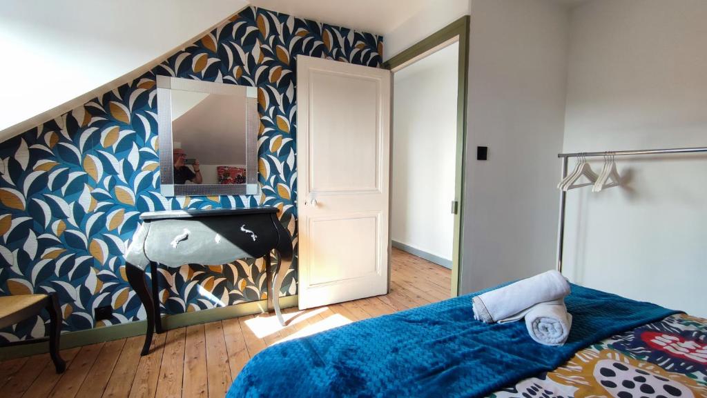 a bedroom with a blue and gold patterned wall at le panoramique in Quimper