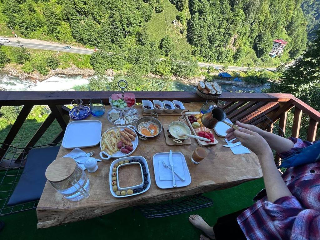 a picnic table with food on top of a bridge at Sisorti süit bungalov in Rize
