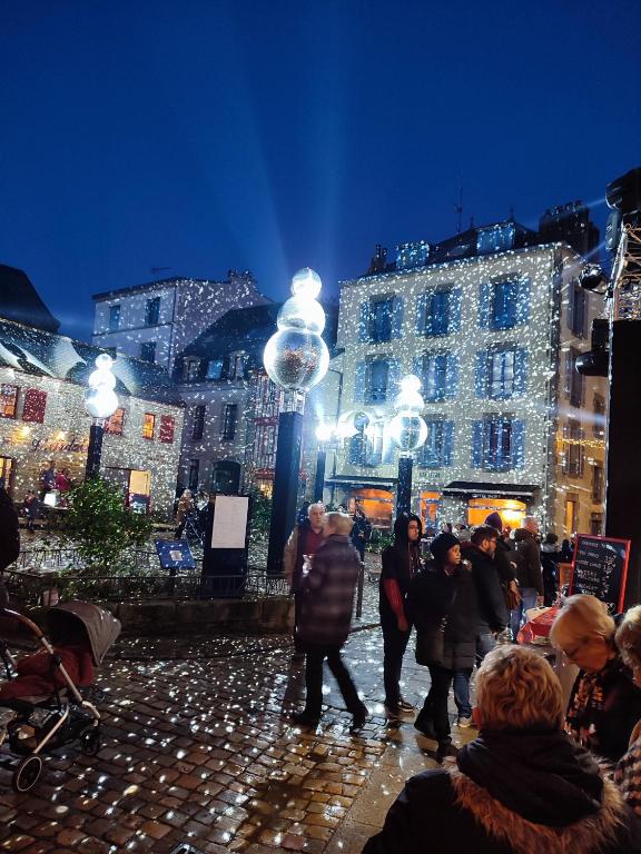 a group of people walking around a city at night at le panoramique in Quimper