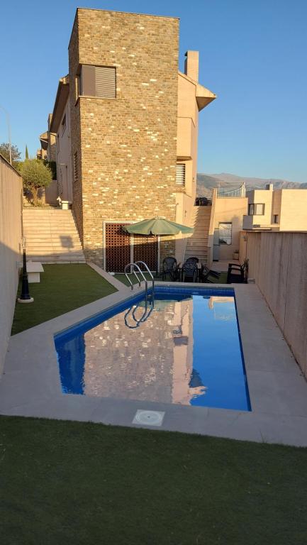 ein Pool in einem Hof neben einem Gebäude in der Unterkunft Casa en Granada zona residencial El Serrallo in Granada