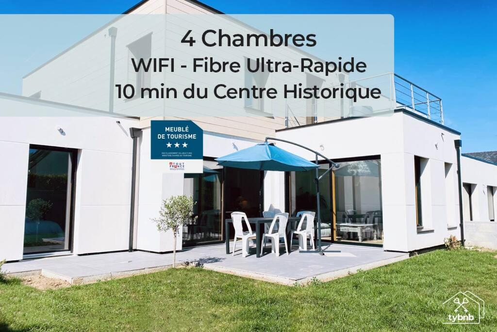a white building with two chairs and an umbrella at Ty Maneguy - Maison neuve et confortable in Vannes