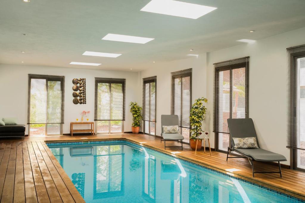 - une piscine dans une maison avec 2 chaises dans l'établissement Villa Laurisilva, à El Sauzal