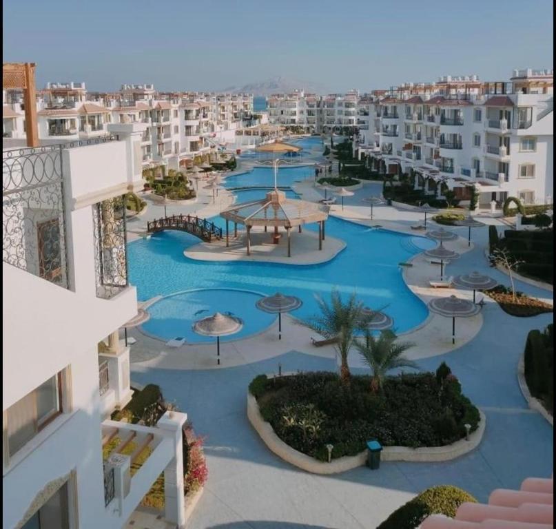 Sharm Hills Aqua park Resort في شرم الشيخ: اطلالة جوية على منتجع فيه مسابح ومظلات