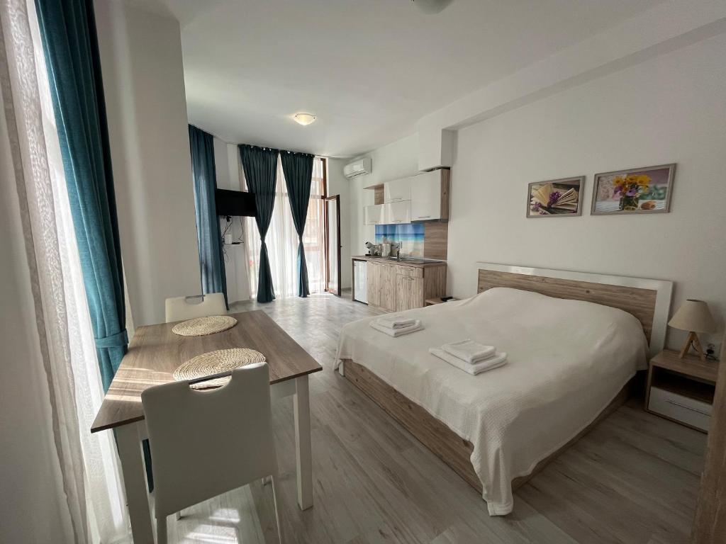 a small bedroom with a bed and a table at Studio Maria Balchik in Balchik