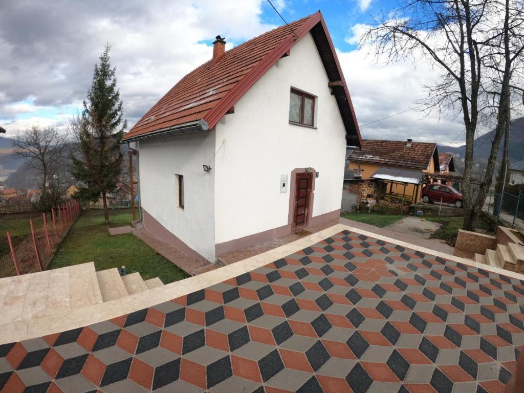 a white house with a red roof with a checkered floor at villa rayan in Hadžići