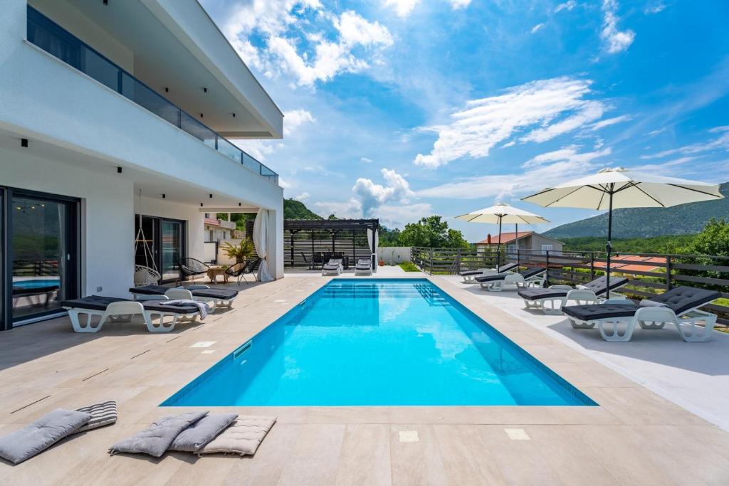 a villa with a swimming pool and a patio at Villa Mirage in Tugare